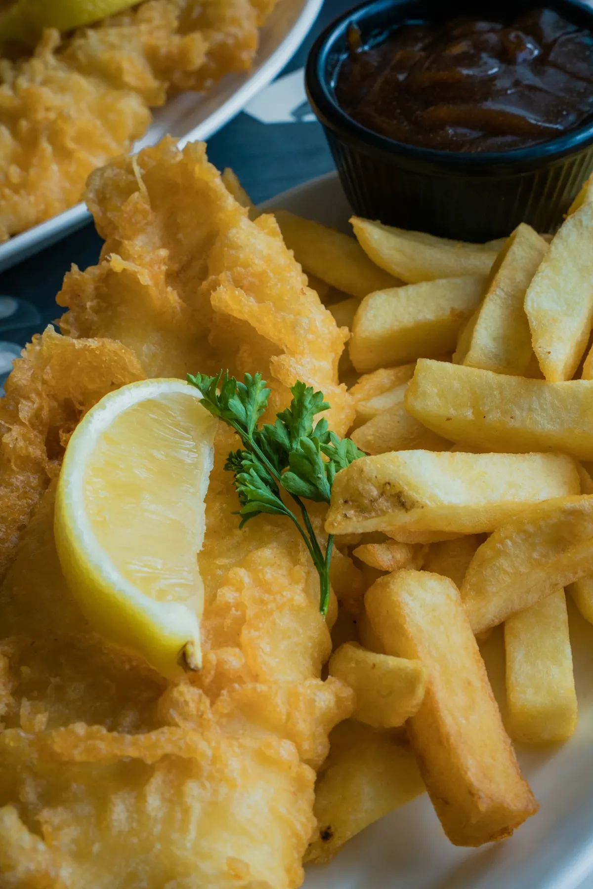 Close-up of battered fish, chips and a lemon wedge