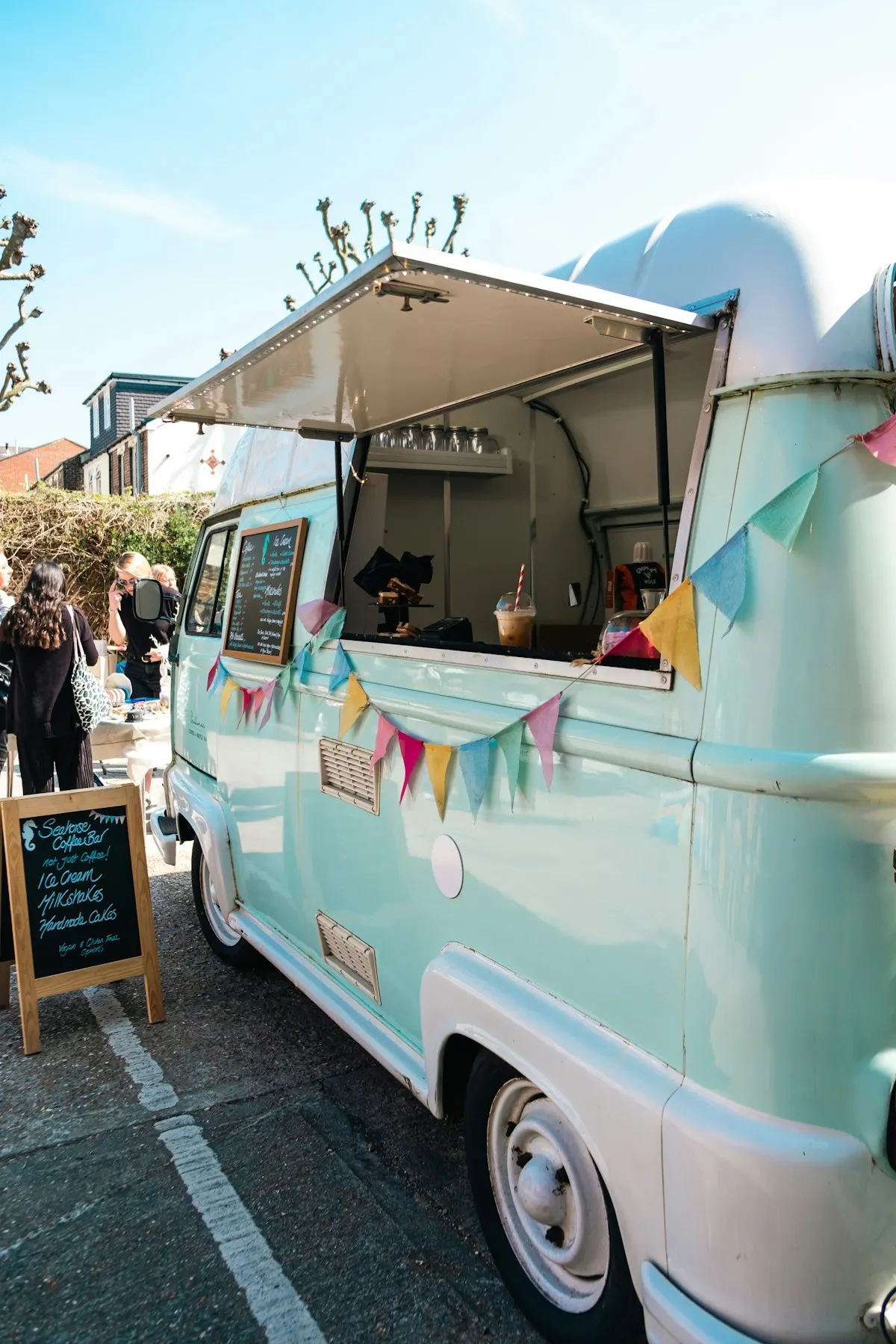 A pale blue vintage-style food van decorated with bunting